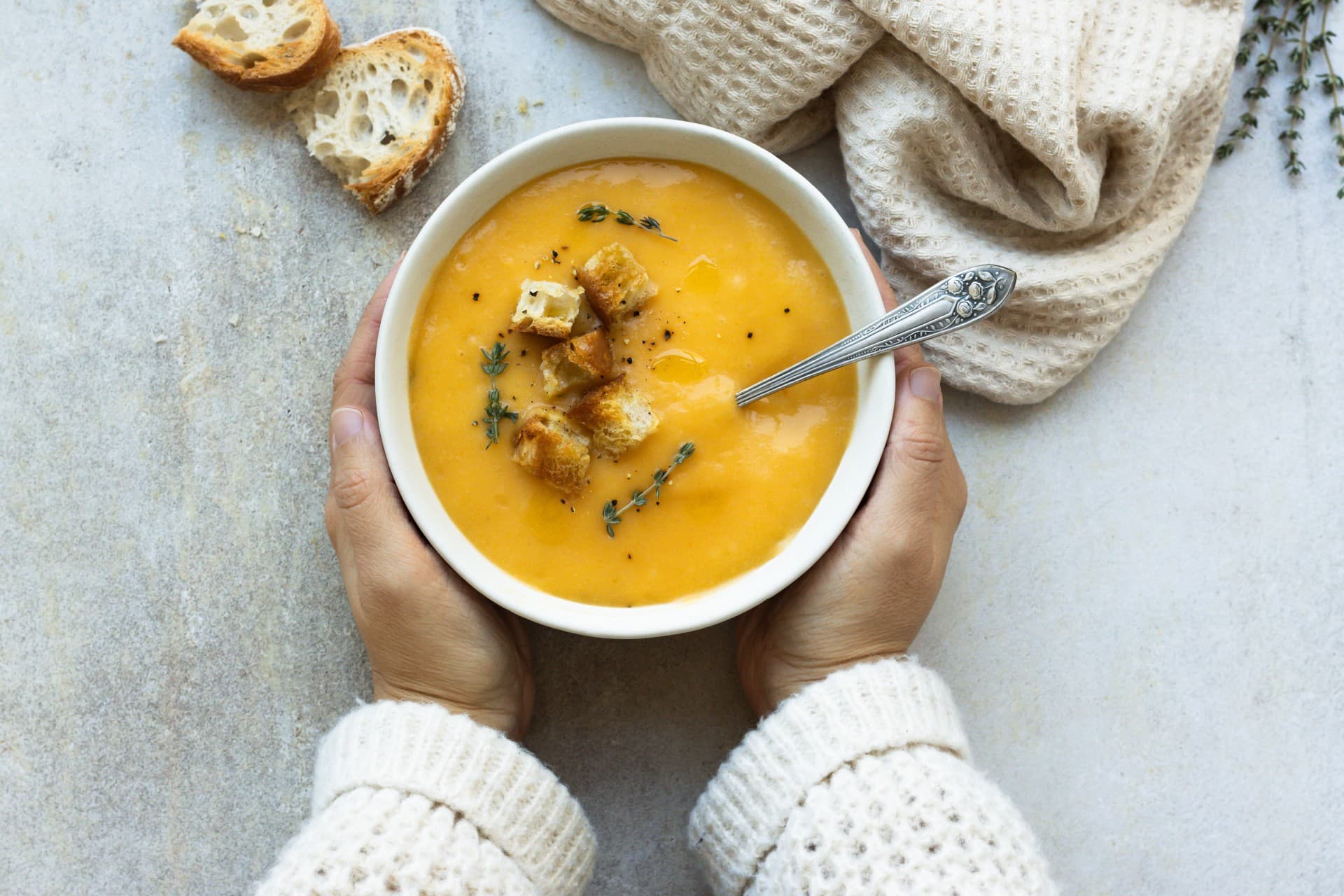 woman holding bowl with creamy pumpkin soup copy space